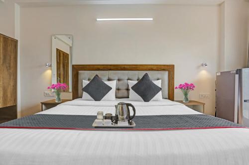 新德里Hotel Luxury Villa Near Delhi IGI Airport的一间卧室配有一张大床,上面装有茶壶