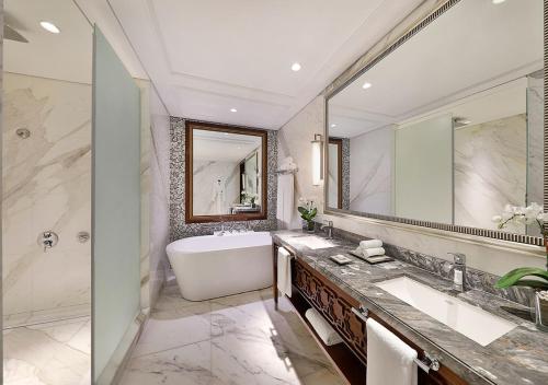 新德里Hotel Luxury Villa Near Delhi IGI Airport的一间带浴缸和大镜子的浴室