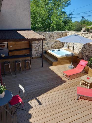 莫尔斯Chez Danièle chambre avec jacuzzi et terrasse privée的木制甲板设有游泳池和桌椅