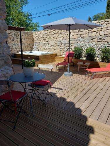 莫尔斯Chez Danièle chambre avec jacuzzi et terrasse privée的庭院配有桌椅和遮阳伞。