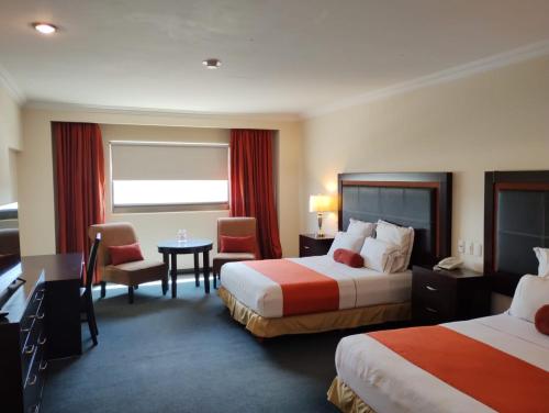 库利亚坎Hotel Two Select的酒店客房带两张床和一张桌子以及椅子。