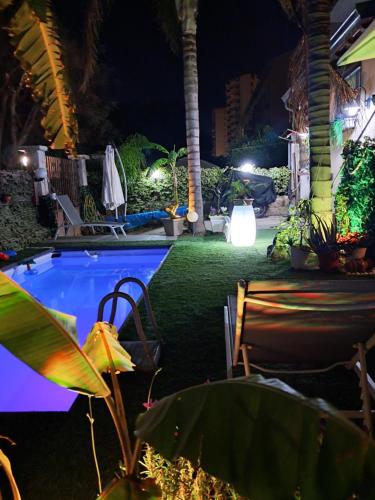 巴勒莫Casa Le Rose的游泳池,晚上配有椅子和植物