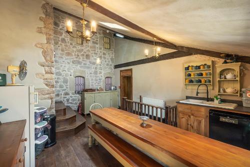 卡尔迪科特Medieval Manor的一间厨房,在房间内配有木凳
