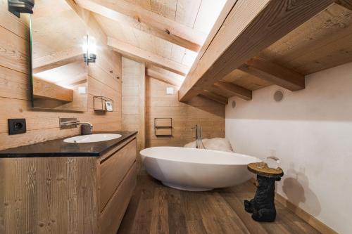 梅杰夫Luxury Megève Chalet, sleeps 8 with Mountain Views and Jacuzzi的设有带木制天花板的浴室内的白色大浴缸