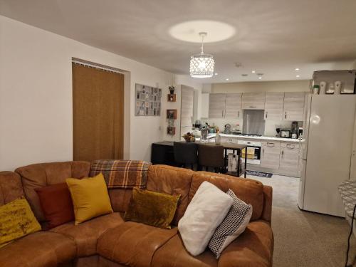 吉林汉姆A stunning room in a 2 bed apartments in the heart of Medway的一间带棕色沙发的客厅和一间厨房
