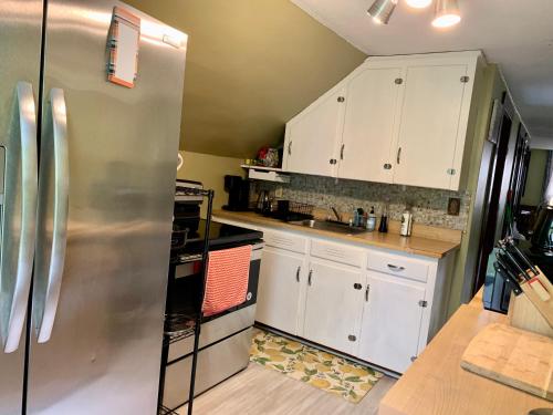奇科皮Cozy 2nd Floor Apartment With Private Entrance的厨房配有白色橱柜和不锈钢冰箱