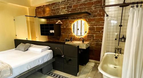 圣玛尔塔Casa Charlotte - Alma Hotels的一间带床、浴缸和水槽的浴室