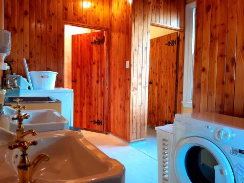 WaipiataPeter's Farm Lodge的一间带洗衣机和水槽的浴室