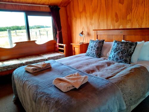 WaipiataPeter's Farm Lodge的一间卧室配有一张大床和两条毛巾