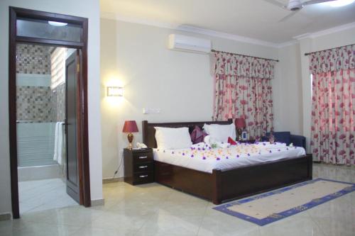 库马西Gold Plus Hotel Ghana的一间卧室设有一张大床和一个窗户。