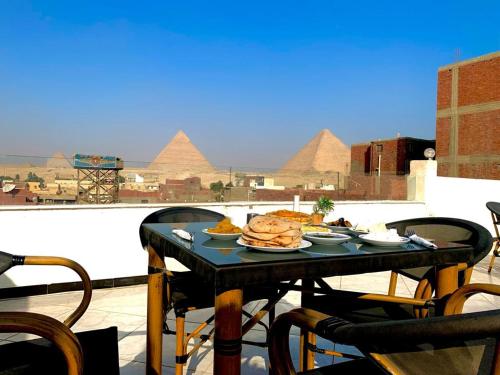 开罗Zoser Pyramids View- Foreiigners only的一张桌子,上面有金字塔背景的食物