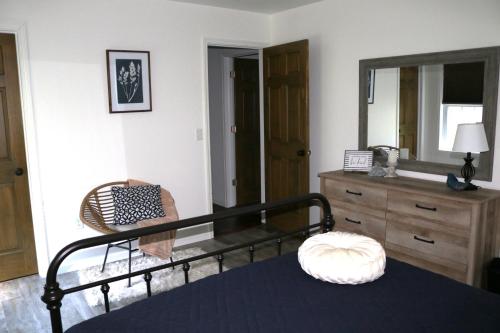 米勒斯堡Country Hills Hideaway的一间卧室配有一张床、梳妆台和镜子