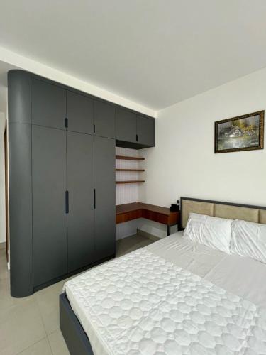 Ấp Rạch MẹoCăn hộ 2 phòng ngủ tầng 10 chung cư cao cấp Sophia Center的卧室配有一张白色大床和橱柜。