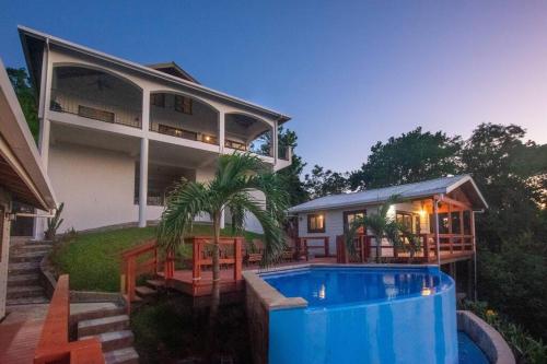 罗阿坦Apricari Villa / Luxury Views / 5 BDRM / Pool的一座房子前面设有游泳池