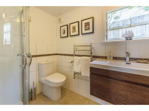 欧尼罗亚Romantic Cottage Recommended by NZ Herald的一间带卫生间、水槽和窗户的浴室