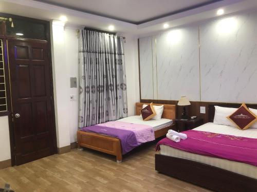 奠边府市Nhà nghỉ Như Ngọc的一间卧室配有两张紫色和白色床单