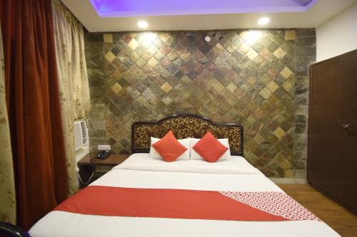 贾姆穆Super OYO Hotel Maa Residency的一间卧室配有带橙色和红色枕头的床
