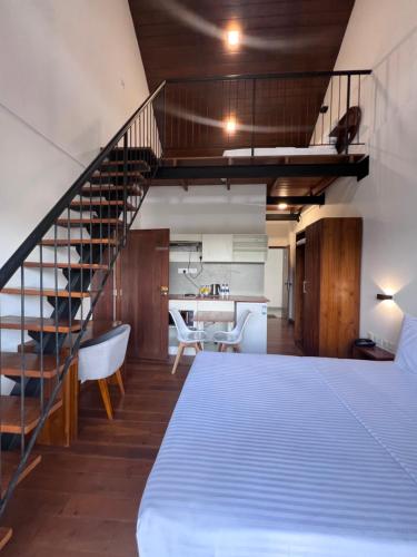 努沃勒埃利耶88th Nuwara Eliya的一间卧室设有一张床和一个螺旋楼梯