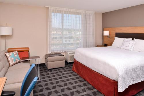 奇诺岗TownePlace Suites by Marriott Ontario Chino Hills的酒店客房,配有床和沙发