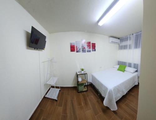 圣萨尔瓦多GYWEL 1214的一间白色卧室,配有床和电视