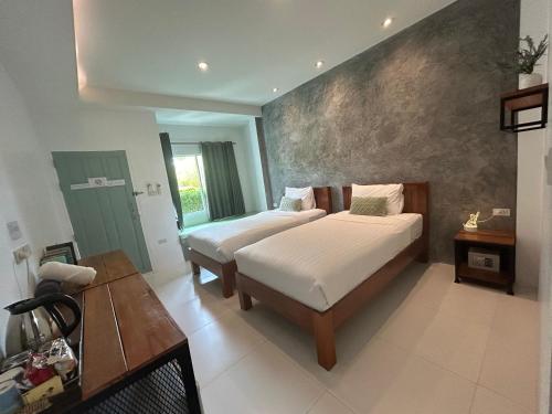 班泰Phangan Hometown Resort - Adults Only的一间卧室配有两张床和一张桌子