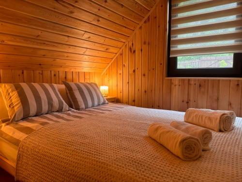 SicasăuAproka - Chalet Mignon Adorable small guest house的木制客房内的一间卧室,配有一张床