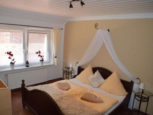 诺德代希Deichjuwel Comfortable holiday residence的一间卧室配有一张带天蓬的大床