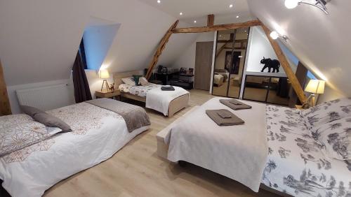 蒙蒂尼亚克Ferme des Petites Oreilles 4 étoiles的一间卧室配有两张床和镜子