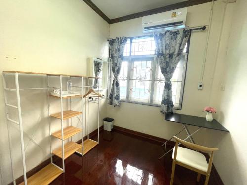 董里2B Cozy Hostel ตรัง的客房设有书桌和窗户。