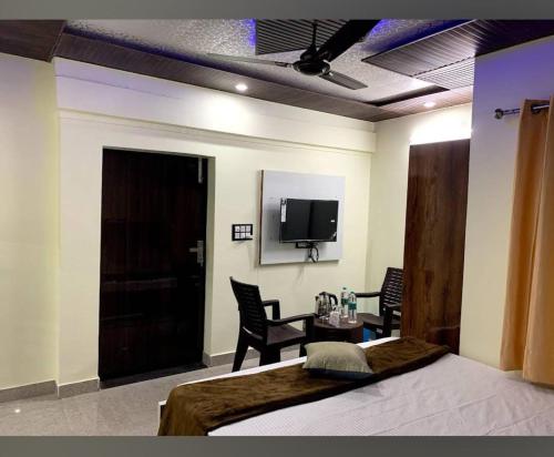 哈里瓦Goroomgo Tapovan Residency Haridwar - Excellent Service Recommended的一间卧室配有一张床、一张桌子和一台电视。