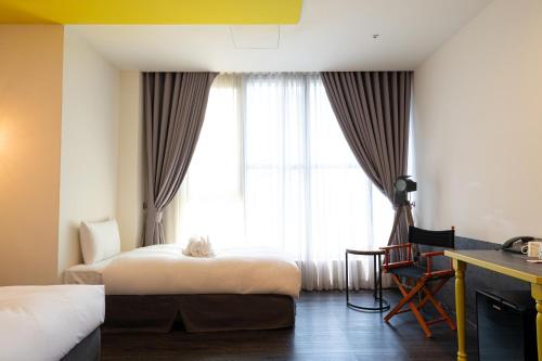 台中市凝萃文旅台中車站店 NCH - NingCui Business Hotel的酒店客房设有两张床和窗户。