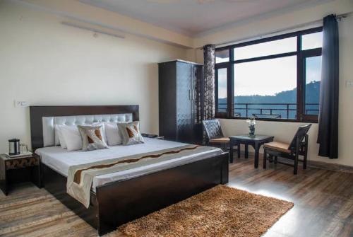 西姆拉Goroomgo शिमला Nature Ville - A Luxury Collection的一间卧室设有一张大床和一个大窗户