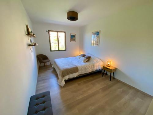 皮亚纳Piana - vue mer et village的一间卧室配有一张床和一张桌子及两个灯