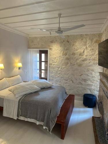 迈伊斯蒂Castellorizon Pensione的一间卧室设有一张床和石墙