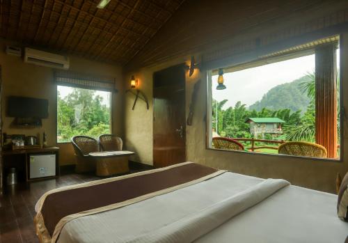 MarchulaTashree Kabeela Riverside Resort的一间卧室设有一张大床和一个大窗户