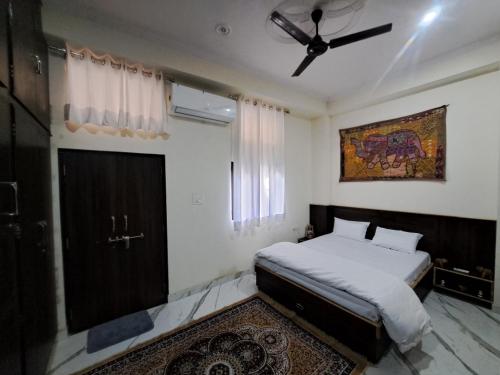 斋浦尔Swaraj Palace的一间卧室配有一张床和吊扇