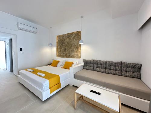 法里拉基Ladiko Inn Hotel Faliraki -Anthony Quinn Bay的客房设有两张床、一张沙发和一张桌子。