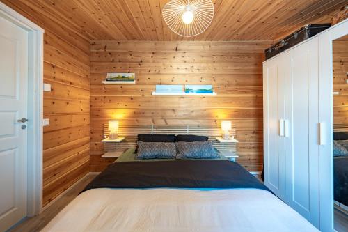 伊纳利Arctic Nature Lodge的卧室配有木墙内的一张床