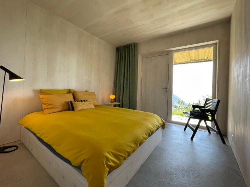 格里翁Chalet contemporain的一间卧室设有黄色的床和窗户。