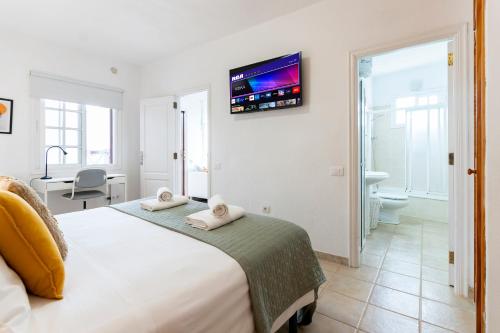 下布雷尼亚Casa El Drago 6的卧室配有一张床,墙上配有电视。