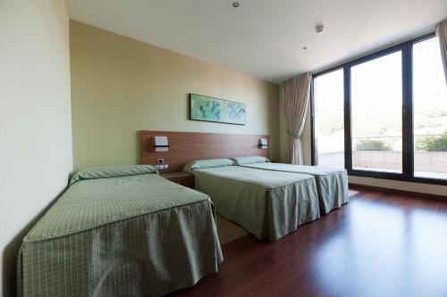 波拉-德拉维亚纳坎赞纳餐厅酒店的酒店客房设有两张床和大窗户。
