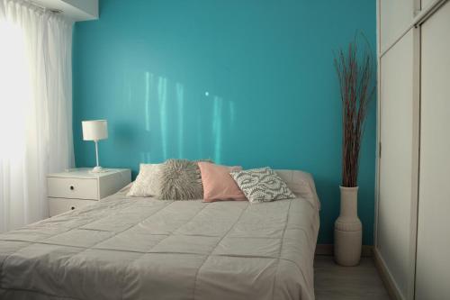 拉莫斯梅希亚Bernardita的一间卧室设有一张蓝色墙壁的大床