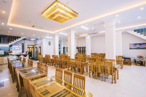 岑山Hương Lý Hotel的一间在房间内配有桌椅的餐厅