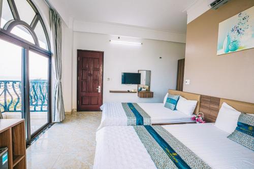 岑山Hương Lý Hotel的酒店客房设有两张床和窗户。