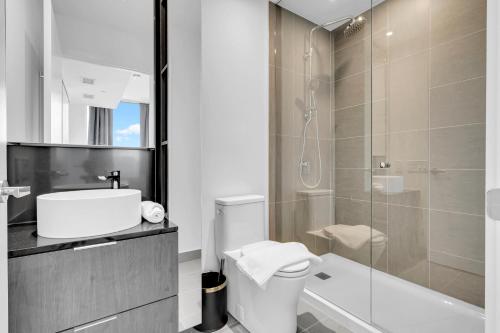 米西索加Modern 2 bedroom 2 bathroom condo steps to Port Credit Go station的一间带卫生间和玻璃淋浴间的浴室