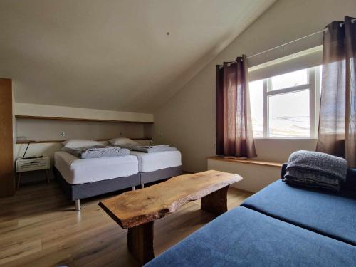 KaldrananesSvansholl Apartments的一间卧室设有两张床和一张木桌