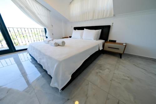 费特希耶Oasis Family-Friendly Luxury Villa Fethiye Oludeniz by Sunworld Villas的一间卧室配有一张大床和两条毛巾