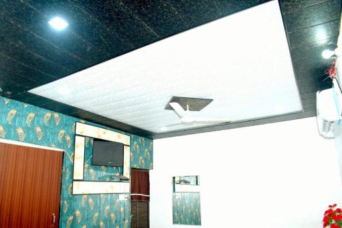 马图拉Radhey Krishna home stay的客房设有带电视和墙壁的天花板。