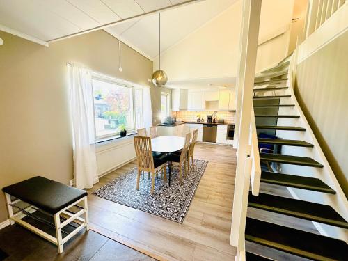诺尔雪平Nyrenoverat 2-våningshus的厨房以及带楼梯和桌子的用餐室