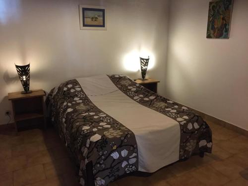 斯基灵角SAFARI Lodge Location Bungalow的一间卧室配有一张床,两盏台灯放在两张桌子上